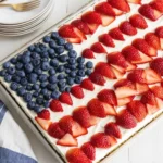 4th of July Desserts American Flag Cake topped with strawberries and blueberries in an American flag design