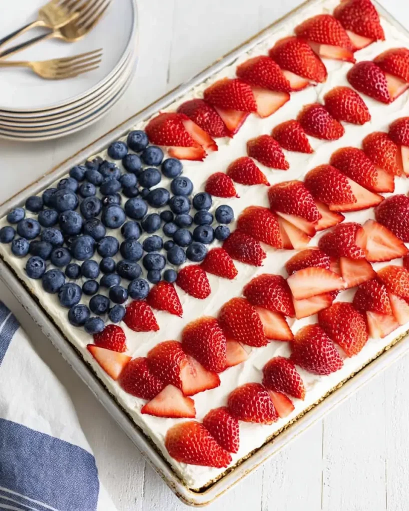 4th of July Desserts American Flag Cake topped with strawberries and blueberries in an American flag design