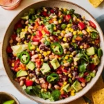 Cowboy Caviar Salad made with beans, corn, avocado, tomatoes, and jalapeños in a serving bowl