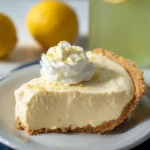 Lemonade Pie slice topped with whipped cream on a graham cracker crust