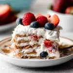 Easy Berry Icebox Cake layered with whipped cream, graham crackers, strawberries, raspberries, and blueberries