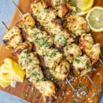 Garlic Parmesan Chicken Skewers grilled with herbs and served with fresh lemon slices