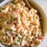 Greek Yogurt Macaroni Salad served in a bowl with peas, carrots, and creamy dressing