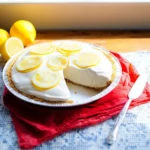 Lemonade Pie topped with whipped cream and fresh lemon slices on a graham cracker crust