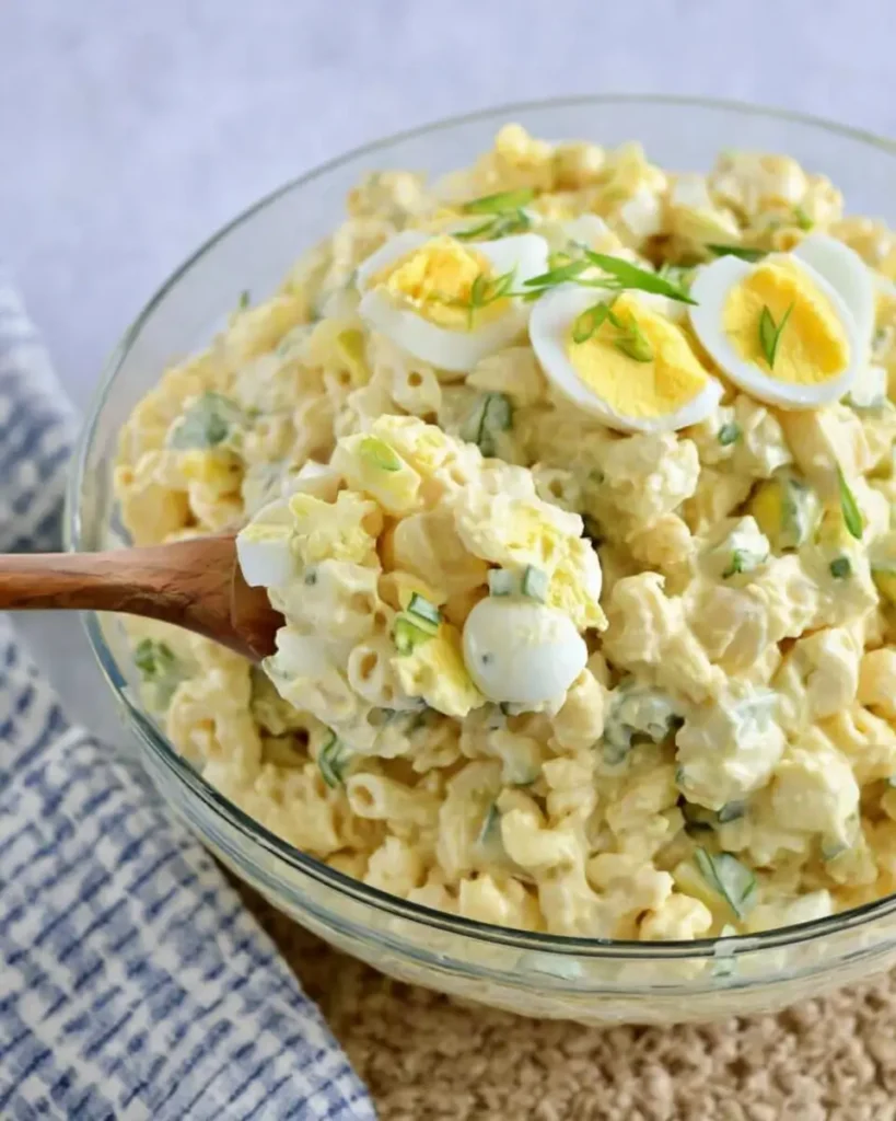 Macaroni Salad with Deviled Eggs served in a bowl with creamy dressing and fresh herbs