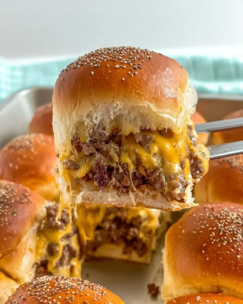 Oven Baked Cheeseburger Sliders filled with melted cheese and seasoned beef on soft buns