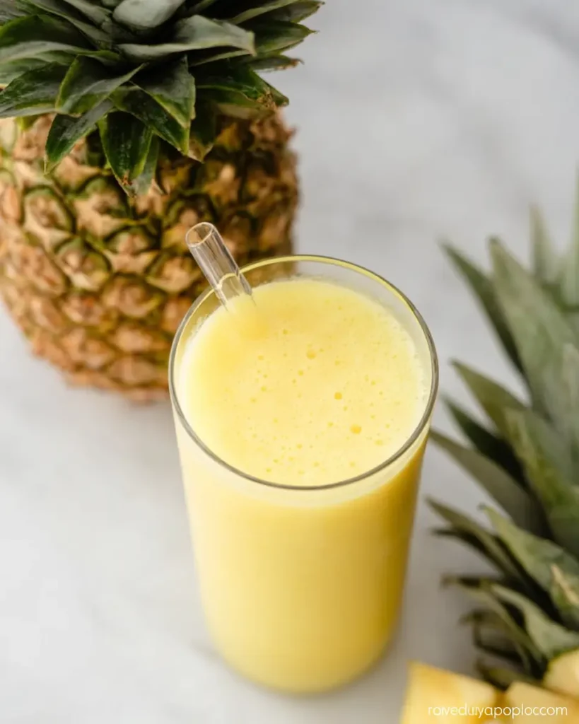 Pineapple Lemonade smoothie served in a tall glass with fresh pineapple