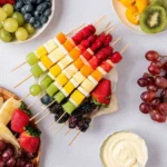 Rainbow Fruit Skewers with strawberries, grapes, melon, pineapple, and blackberries