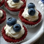Red, White & Blue Cookie Cups topped with creamy filling and fresh blueberries on a white serving tray