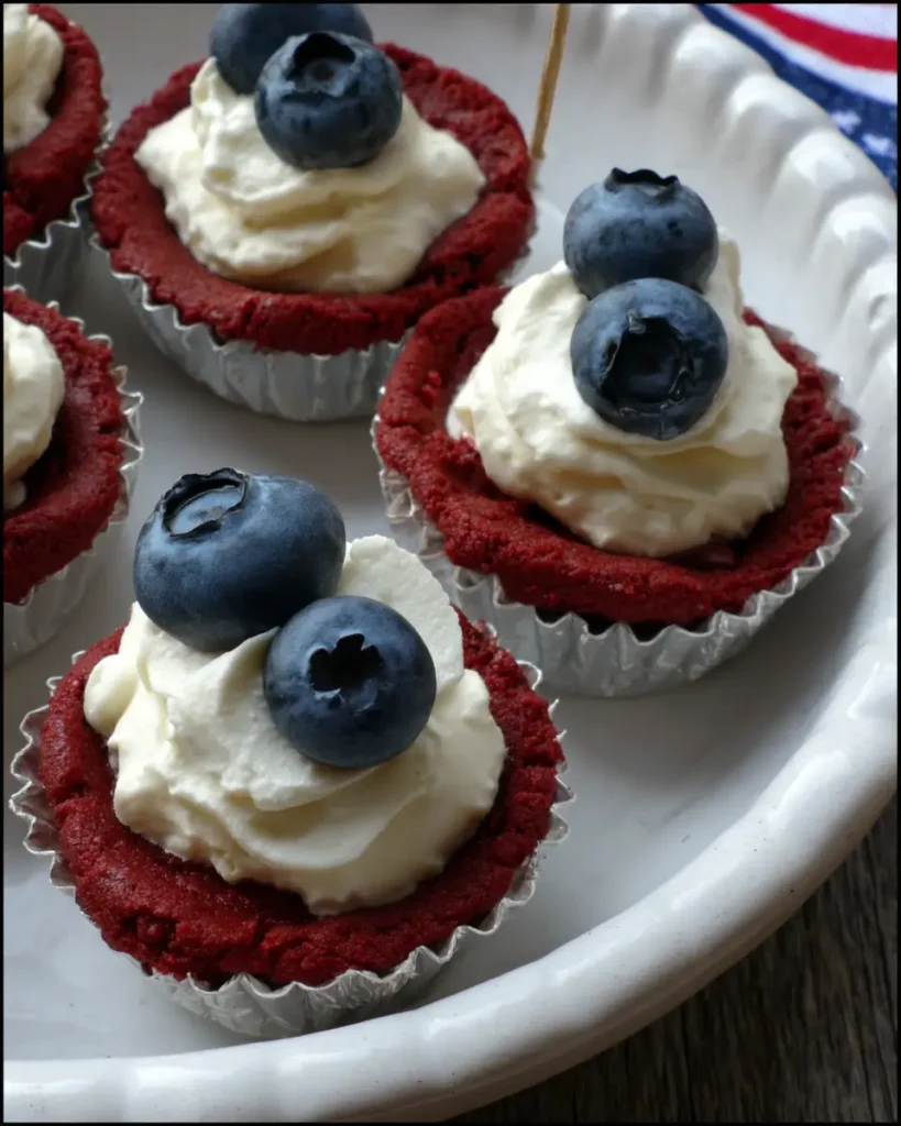 Red, White & Blue Cookie Cups topped with creamy filling and fresh blueberries on a white serving tray